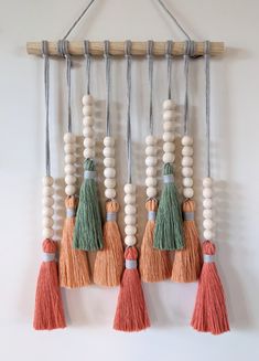 a wall hanging with tassels and beads