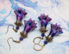 Boho dangle earrings, flower earrings. Hand painted and color sealed purple flower earrings with a splash of royal-blue, baby blue and burgundy shimmer accompanied by purple mini-inner flowers with royal blue faceted crystal accent beads. Dressed up or down no matter the occasion these colorful flower earrings are sure to compliment you. Earrings are lightweight and can be worn comfortably all day long. Gift for a loved one? Birthday gift for her? Coworker gift? Friendship gift?  How about treat Painted Gifts, Flowers Earrings, Hand Painted Gifts, Painted Flower, Purple Earrings, First Birthday Gifts, Earrings Boho, Friendship Gifts, Hand Made Jewelry