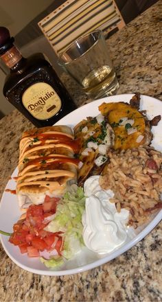 a white plate topped with lots of food next to a bottle of boojute