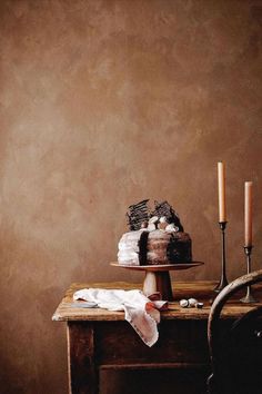 a table topped with a cake next to two candles