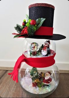 a snowman in a top hat and scarf is inside a fish bowl filled with ornaments