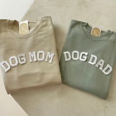 two sweatshirts with the words dog mom and dad on them sitting next to each other