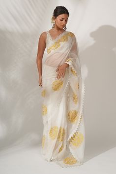 Ivory silk organza saree with resham and patra embroidery, highlighted with a cotton lace. Paired with an ivory raw silk scallop blouse enhanced with patra and sequins embroidery.
Component: 2
Pattern: Embroidered
Type Of Work: Patra, Resham work
Neckline: Scoop 
Sleeve Type: Sleeveless
Fabric: Raw Silk, Silk Organza
Color: White
Other Details: 
Lace border
Floral motifs
Embroidered blouse
Occasion: Puja,Wedding - Aza Fashions Alia Bhatt Saree, Bollywood Designer Sarees, White Saree, Embroidery Saree, Stylish Sarees, Organza Saree, Saree Look, Alia Bhatt, Silk Organza