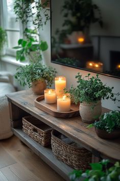 some candles are sitting on a table in front of a mirror and potted plants