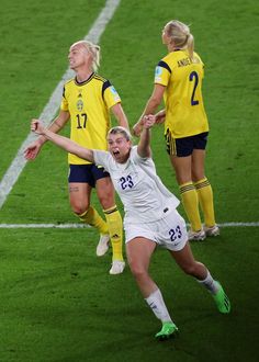 two female soccer players colliding for the ball