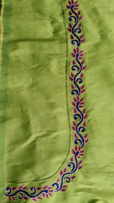 an embroidered green cloth with blue and pink designs