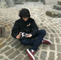 a person sitting on the ground with a camera