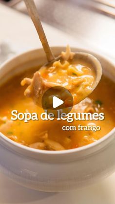 a bowl of soup with a spoon in it and the words sopa de legumes com frango