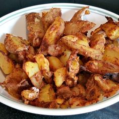 a white bowl filled with cooked potatoes on top of a table