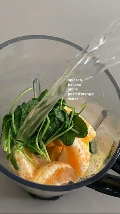 a blender filled with oranges and spinach