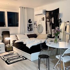 a white living room with black and white decor on the walls, tables and chairs