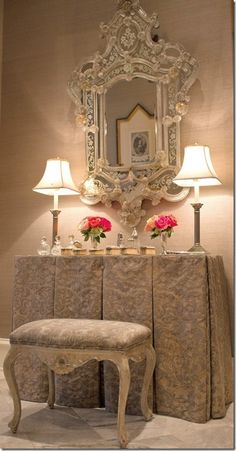 an ornately decorated table and chair in front of a mirror with flowers on it