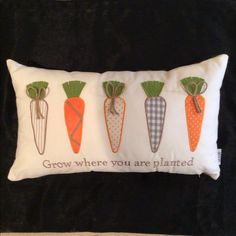 three carrots on a pillow with the words grow where you are planted