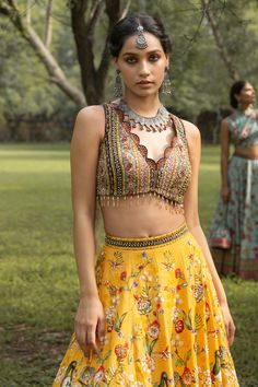 Yellow lehenga with all-over floral print and delicate embellishments. Comes with embroidered sleeveless blouse and soft net aqua dupatta in chitta work.
Component: 3
Printed, Embroidered
Neckline: V-Neck
Sleeve Length: Sleeveless
Fabric: Dola Silk
Color: Yellow 
Embroidered blouse with beaded tassels
Scallop edged neckline and lehenga hem
Printed and embroidered dupatta border
Tie-up at the back
 - Aza Fashions Designer Bohemian Lehenga With Multicolor Embroidery, Designer Multicolor Embroidered Bohemian Lehenga, Bohemian Multicolor Embroidered Lehenga For Designer Wear, Navratri Choli With Floral Embroidery, Bohemian Lehenga With Motifs For Reception, Bohemian Choli With Multicolor Embroidery For Reception, Bohemian Anarkali Set With Floral Embroidery For Wedding, Bohemian Wedding Choli With Floral Embroidery, Festive Floral Print Sets For Reception