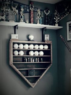 an old baseball bat shaped shelf is displayed in the corner of a room with other items on it