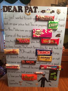 a sign that has candy on it with words written in front of it and pictures attached to the board