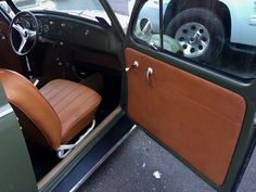 the interior of an old car with brown leather seats and steering wheel, parked in a parking lot