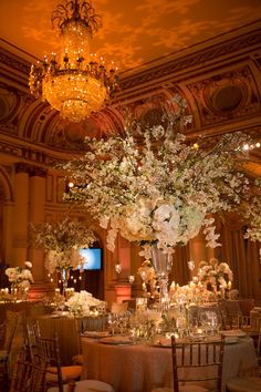 an elegant wedding reception with tall centerpieces and flowers