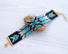 a blue and black beaded dog collar on a white wooden surface with gold chain