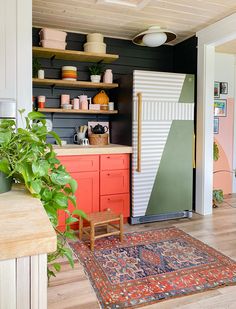 a kitchen with an area rug, potted plants and other items on the shelves