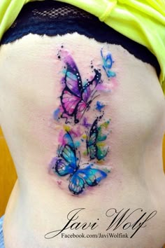 the back of a woman's stomach with butterflies painted on her belly and behind it is