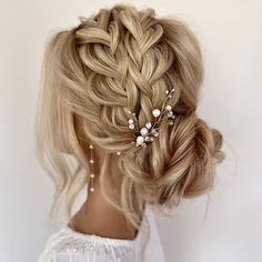 a woman with blonde hair wearing a braided updo and pearls in her hair