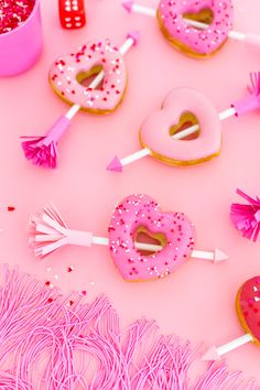 pink donuts and candy lollipops on a table