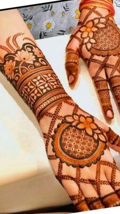 two hands with henna designs on them, one is showing it's intricate design