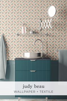 a bathroom with a sink, mirror and towel on the wall next to it is a blue cabinet