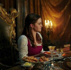 a woman sitting at a table with food on it