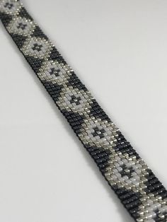 a black and white beaded bracelet on a table