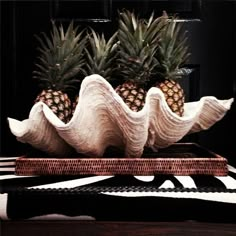 two pineapples are sitting on top of a tray with white waves in it