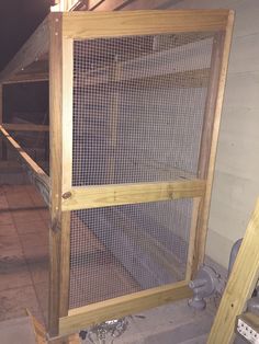 a chicken cage in the corner of a building with no doors or windows on it