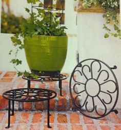 a potted plant sitting on top of a metal stand next to a small table