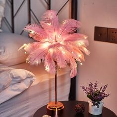 a pink palm tree sitting on top of a table next to a vase filled with flowers