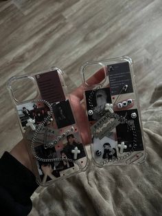 two clear cell phones with photos and words attached to the back of them, sitting on top of a bed