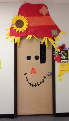 a door decorated to look like a scarecrow with a sunflower on his head