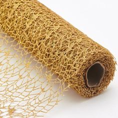 a roll of gold colored net sitting on top of a white surface