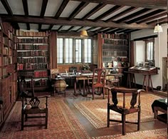 an old fashioned library with many bookshelves and chairs