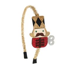 Holiday headband features nutcracker design. Coordinating purse is available.