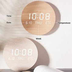 two clocks with the time displayed on them are shown next to an alarm clock and a roll of toilet paper