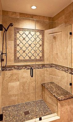 a walk in shower sitting next to a tiled wall and floor with a bench on the side