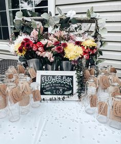 flowers in mason jars are on the table for guests to sit down and sign their names