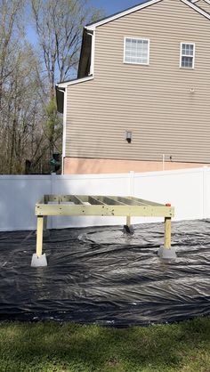 a house that is covered in tarp next to a fence