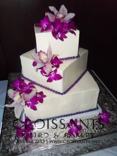 a three tiered cake with purple flowers on top