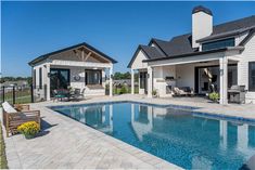 an outdoor pool and patio area next to a house with a large swimming pool in the middle