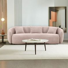 a living room with a pink couch and coffee table