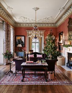 a living room filled with furniture and a christmas tree on top of a wooden table