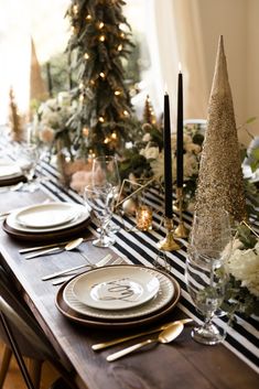 a table set for christmas with candles and plates