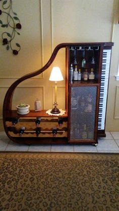 an old fashioned musical instrument is sitting on the floor next to a lamp and rug